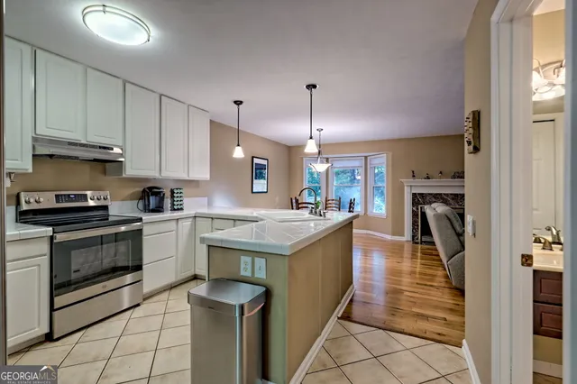 a kitchen with granite countertop a sink stove and cabinets
