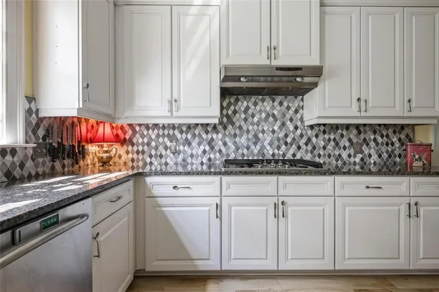 a kitchen with white cabinets and sink