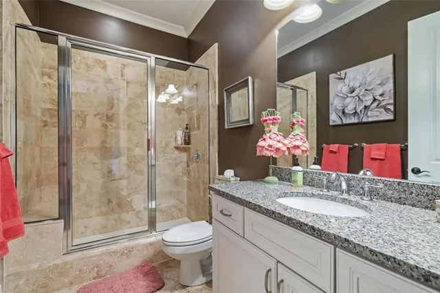 a bathroom with a granite countertop sink mirror vanity and toilet