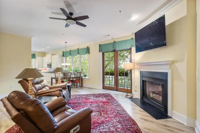 a living room with furniture a fireplace a flat screen tv and a large window