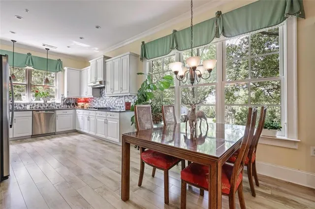 a kitchen with a table chairs and wooden floor