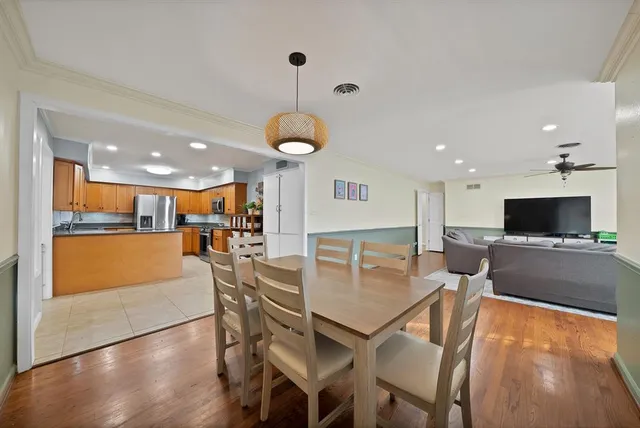 a living room with furniture a flat screen tv and kitchen view