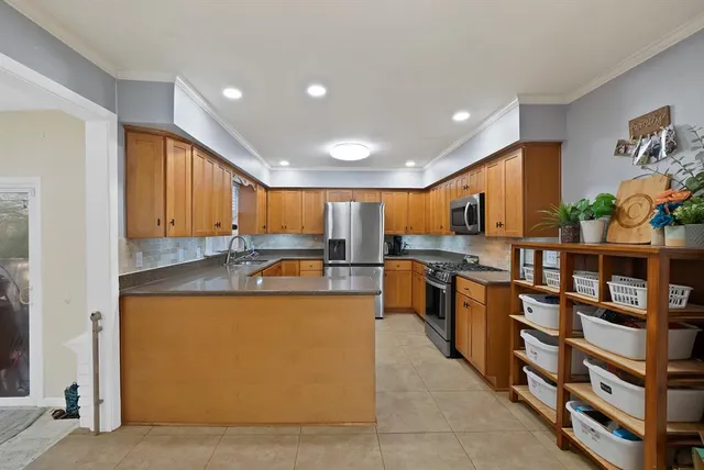 a kitchen with stainless steel appliances granite countertop sink window and cabinets