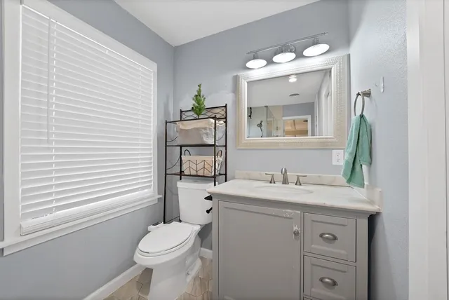 a bathroom with a toilet a sink and mirror