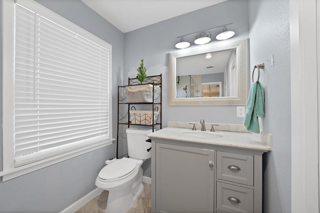 5705 Blue Ridge Drive Fort Worth, TX 76112 - Photo 27 of 40 a bathroom with a toilet a sink and mirror