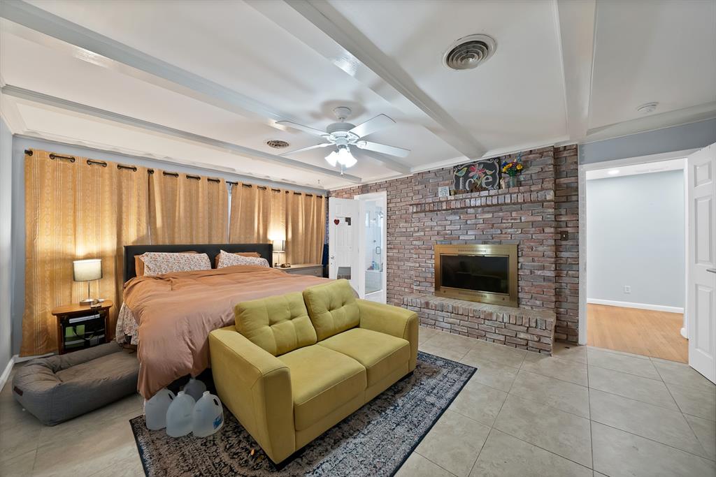5705 Blue Ridge Drive Fort Worth, TX 76112 - Photo 31 of 40 a spacious bedroom with a bed a fireplace and a couch