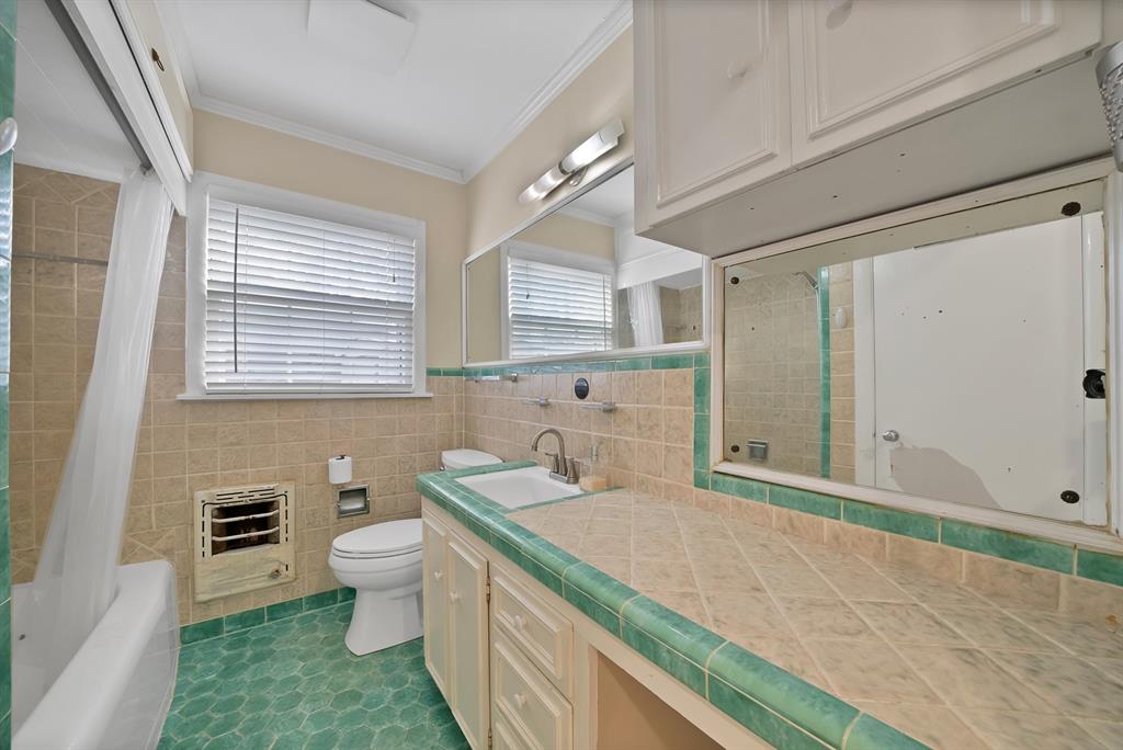 5705 Blue Ridge Drive Fort Worth, TX 76112 - Photo 37 of 40 a bathroom with a granite countertop sink a toilet a mirror and bathtub