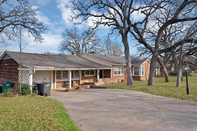 a front view of a house with a yard and trees