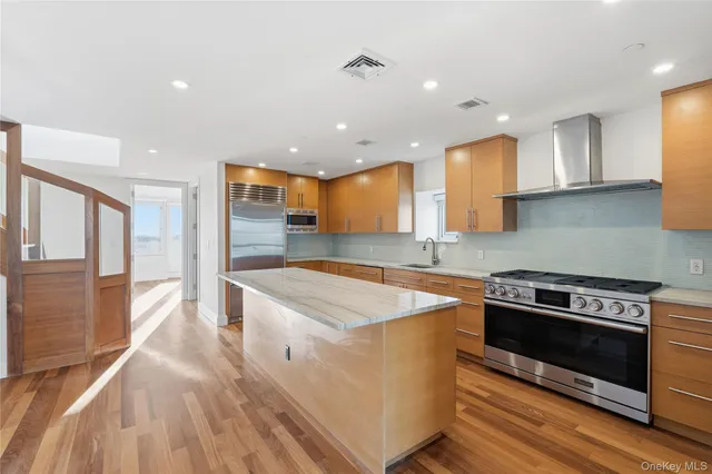 a kitchen with stainless steel appliances granite countertop a stove a sink and a refrigerator
