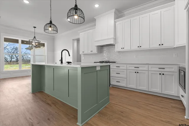 a kitchen with cabinets a sink and dishwasher stove with wooden floor