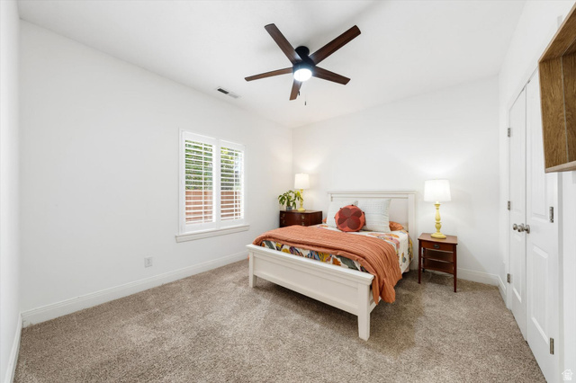 621 East 940 South St. George, UT 84790 - Photo 33 of 55 Carpeted interior room featuring a window with white louvered shutters, a ceiling fan with integrated lighting, and white baseboards