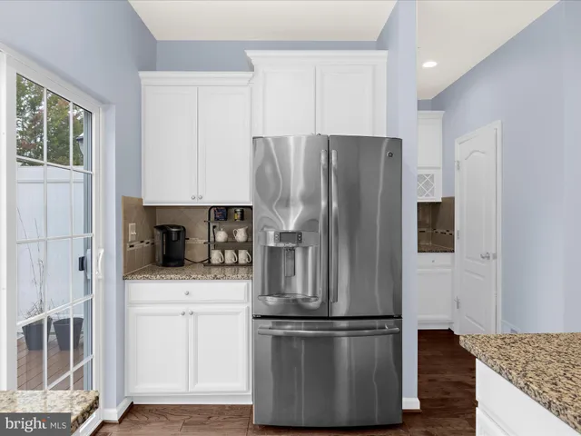 a kitchen with stainless steel appliances granite countertop a refrigerator and a stove top oven