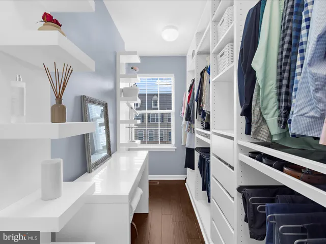 a view of walk in closet with clothes and shoes