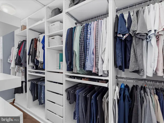 a view of walk in closet with clothes and shoes