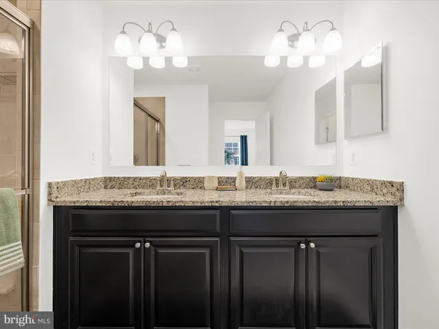 a bathroom with a granite countertop sink and a mirror