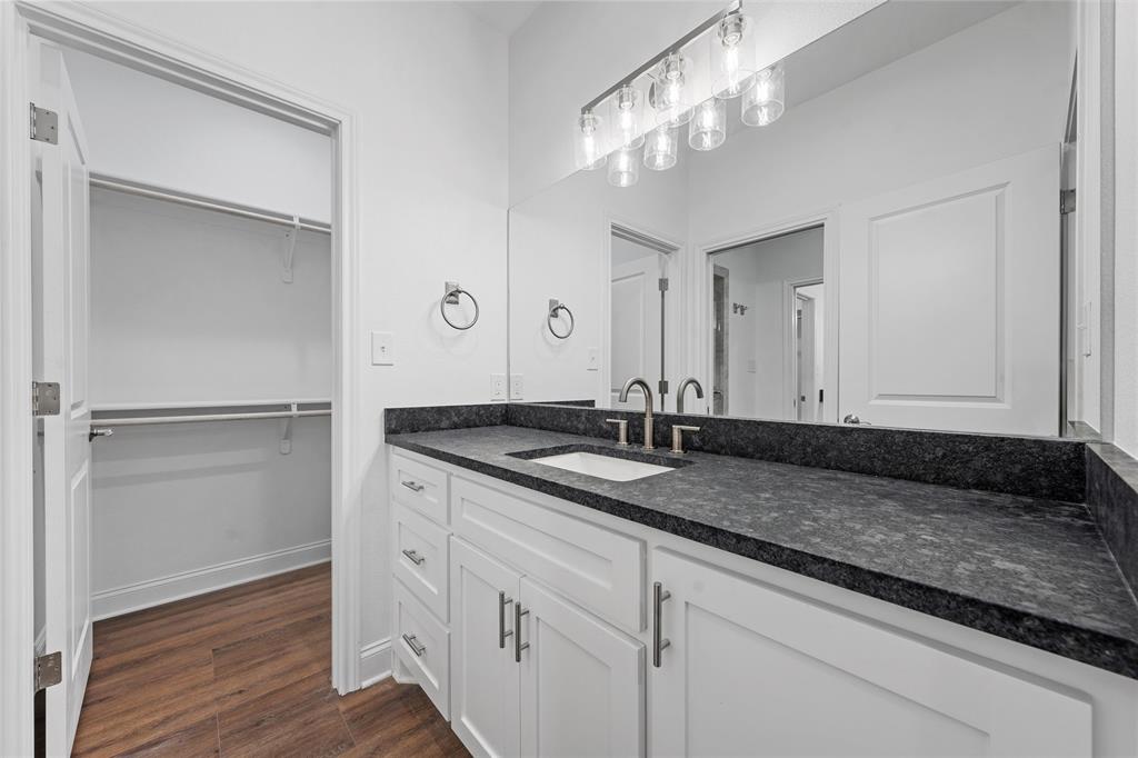 1698 Rogers Hill Road Waco, TX 76705 - Photo 23 of 40 Bathroom with vanity, wood finished floors, a spacious closet, and baseboards