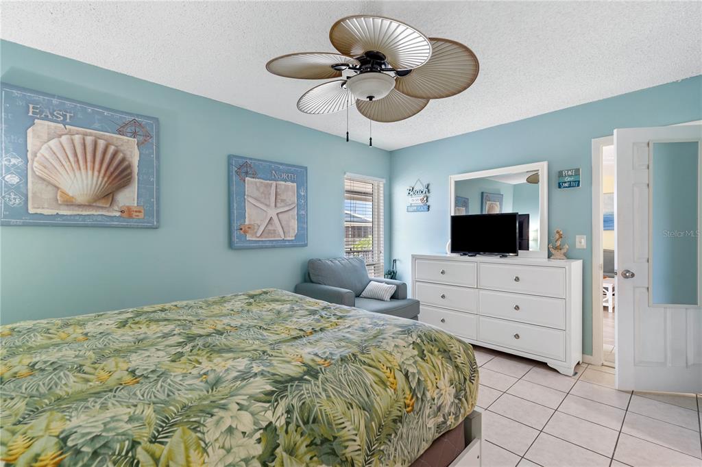 230 Medallion Boulevard, Unit E Madeira Beach, FL 33708 - Photo 14 of 35 a bedroom with a large bed and a flat screen tv