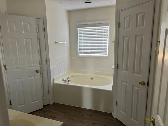 a bathroom with a tub a sink and a window