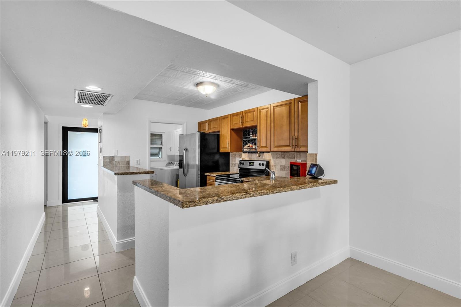 3785 Raleigh Street Hollywood, FL 33021 - Photo 11 of 36 a kitchen with stainless steel appliances granite countertop a sink refrigerator and microwave