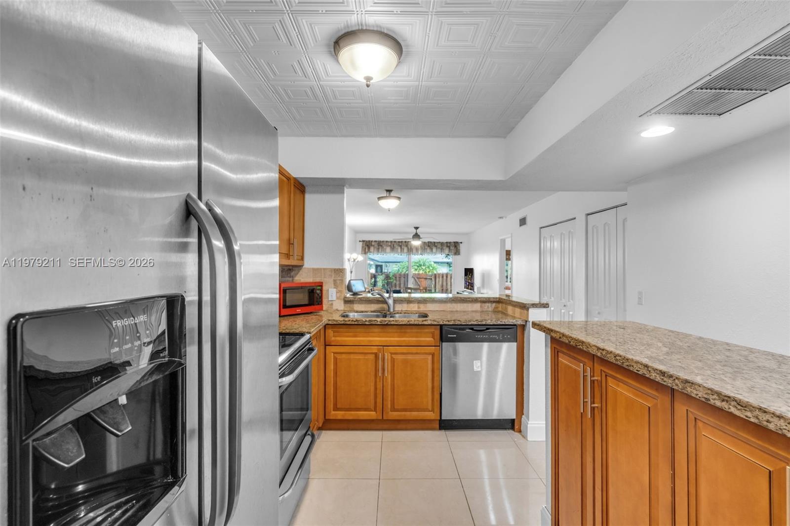 3785 Raleigh Street Hollywood, FL 33021 - Photo 13 of 36 a kitchen with stainless steel appliances granite countertop a sink stove and refrigerator