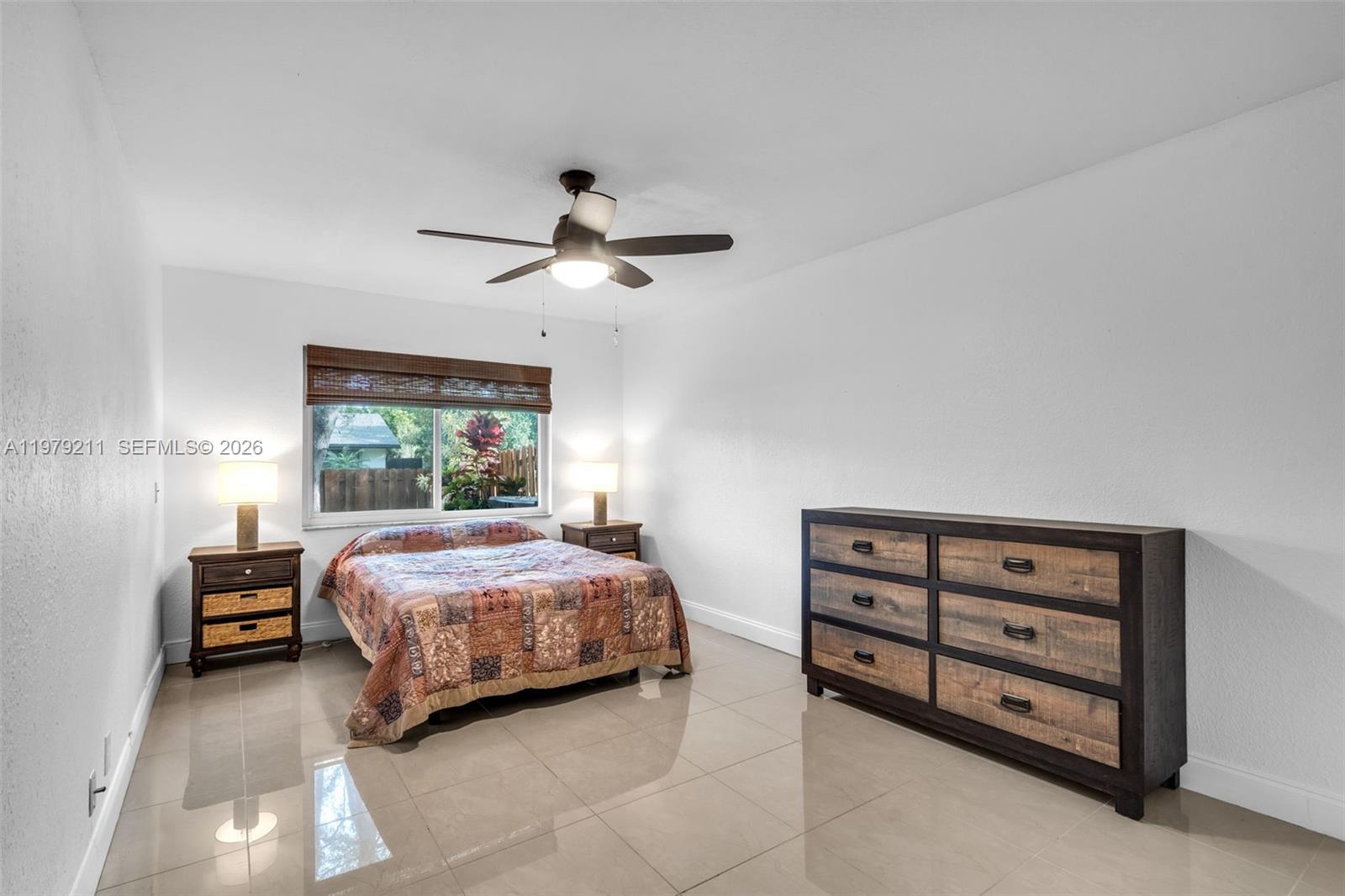 3785 Raleigh Street Hollywood, FL 33021 - Photo 15 of 36 a bedroom with a bed a chandelier and a window
