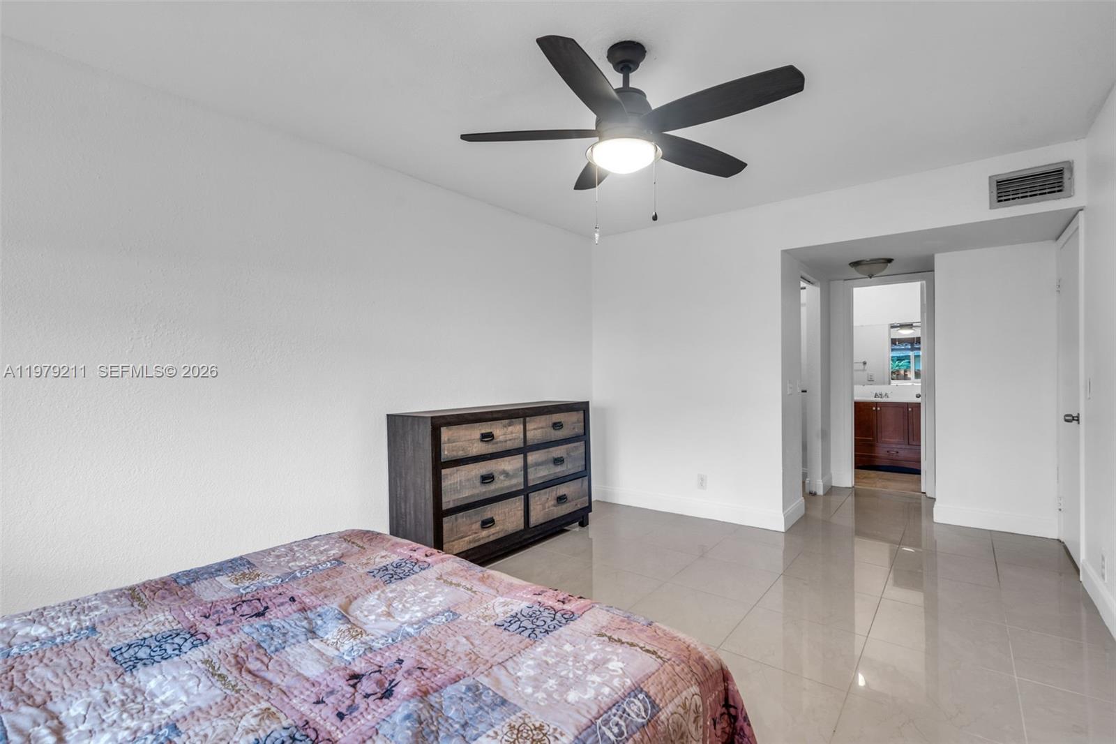 3785 Raleigh Street Hollywood, FL 33021 - Photo 17 of 36 a bedroom with a bed and a chandelier