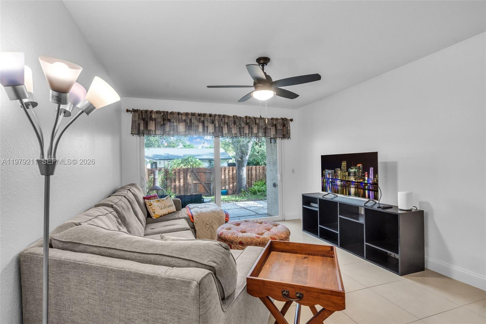 3785 Raleigh Street Hollywood, FL 33021 - Photo 7 of 36 a living room with furniture a large window and a chandelier