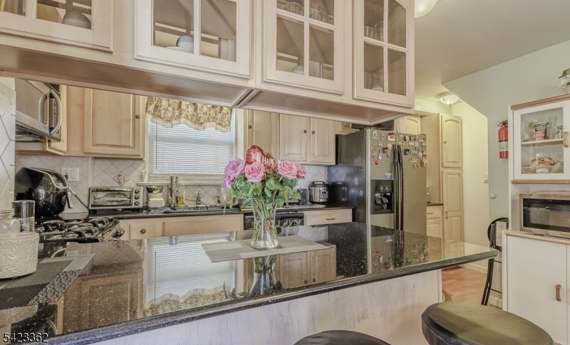 66 Garrison Street Newark, NJ 07105 - Photo 13 of 25 a kitchen with stainless steel appliances granite countertop a refrigerator a stove and a sink