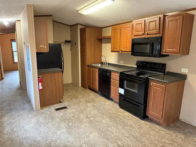 a kitchen with stainless steel appliances granite countertop a refrigerator stove and sink