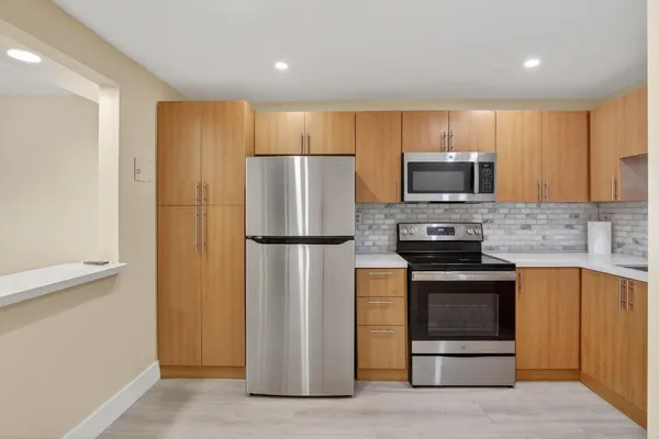 a kitchen with stainless steel appliances a refrigerator stove microwave and sink