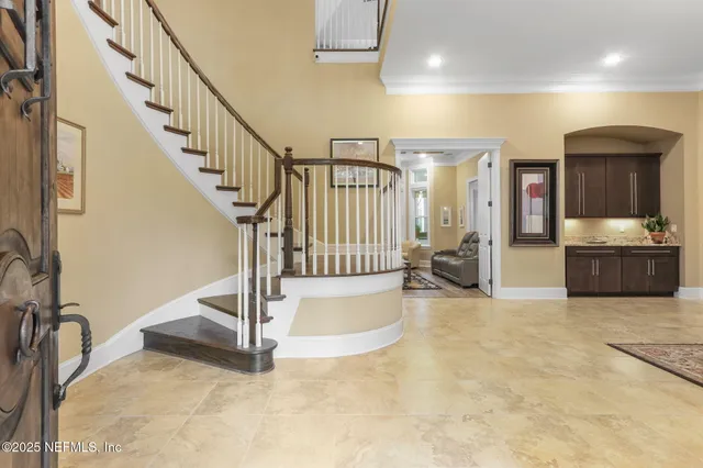 a view of a dining room with furniture a kitchen and chandelier