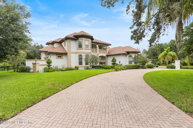 a front view of a house with a yard and fountain