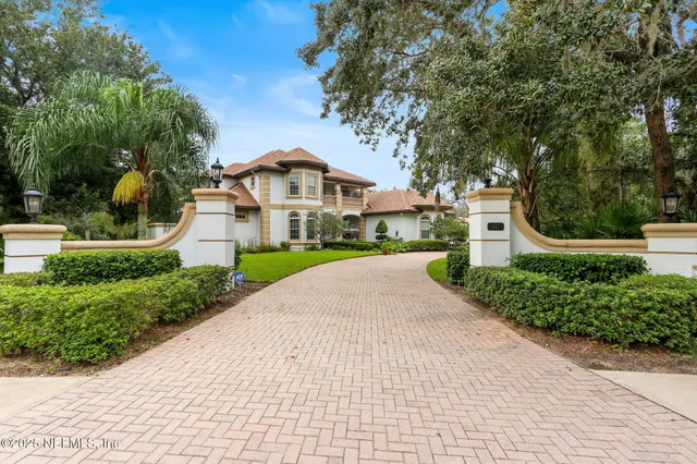 a front view of a house with a yard and potted plants
