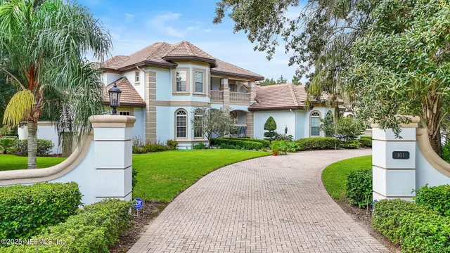 a front view of a house with a yard and potted plants