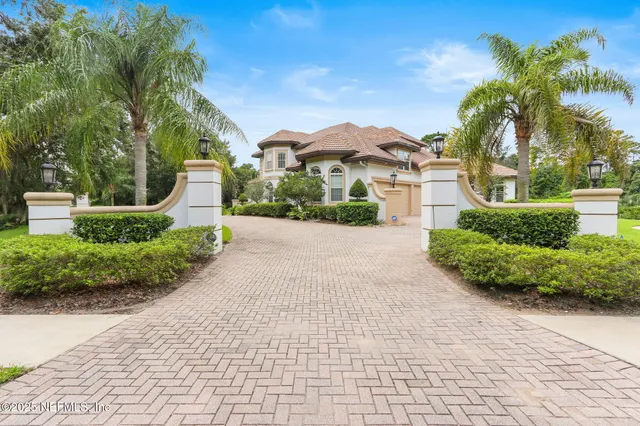 a view of a house with a big yard and large trees