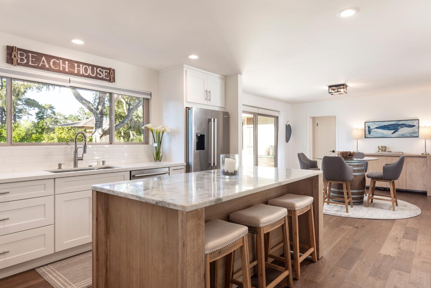 3128 Stevenson Drive Pebble Beach, CA 93953 - Photo 14 of 35 a kitchen with stainless steel appliances granite countertop a table chairs sink and wooden cabinets