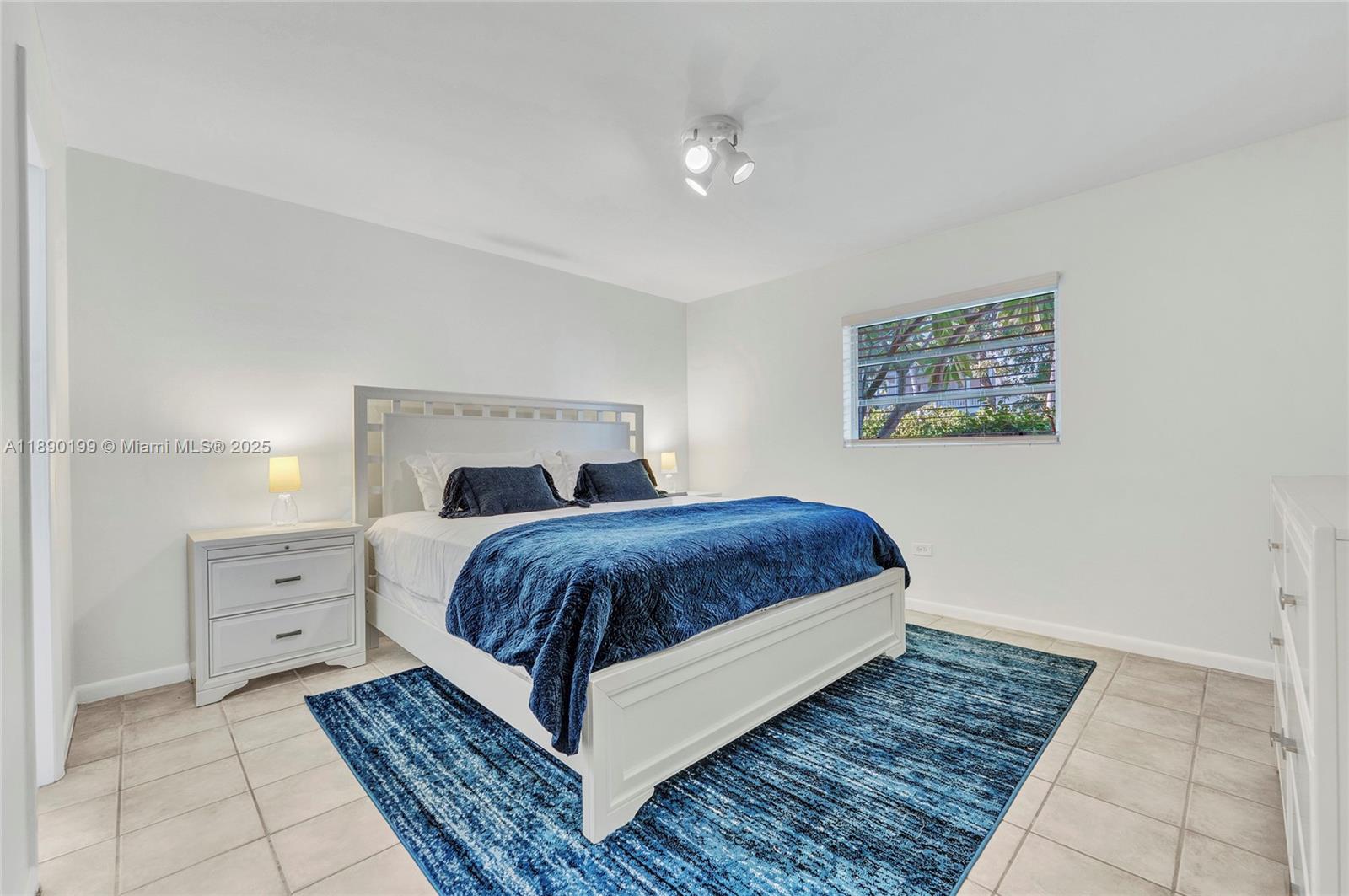 1129 Pebble Beach Lane, Unit 6 Marathon, FL 33050 - Photo 16 of 31 a bedroom with a large bed and a chandelier