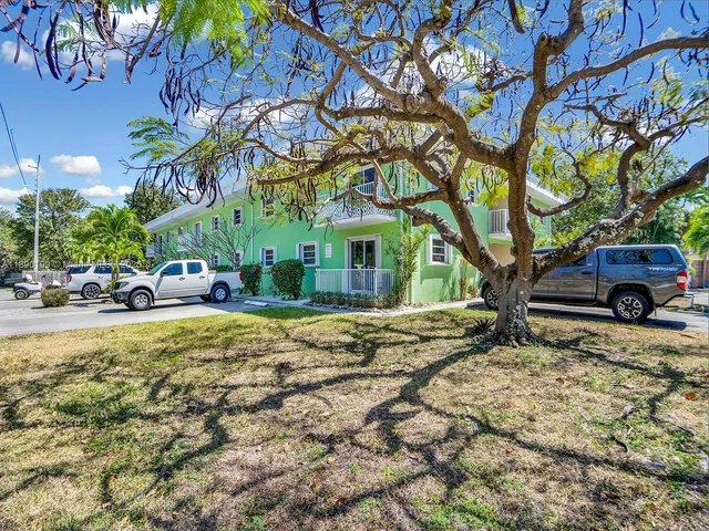 a view of a yard in front of a house with large tree