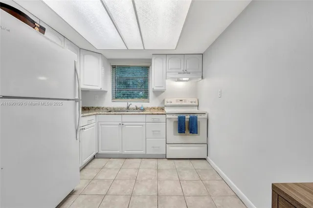 a kitchen with white cabinets and white appliances