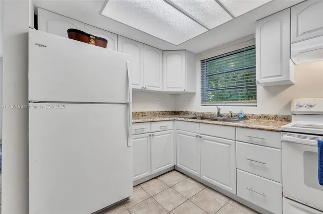 a white refrigerator freezer sitting inside of a kitchen