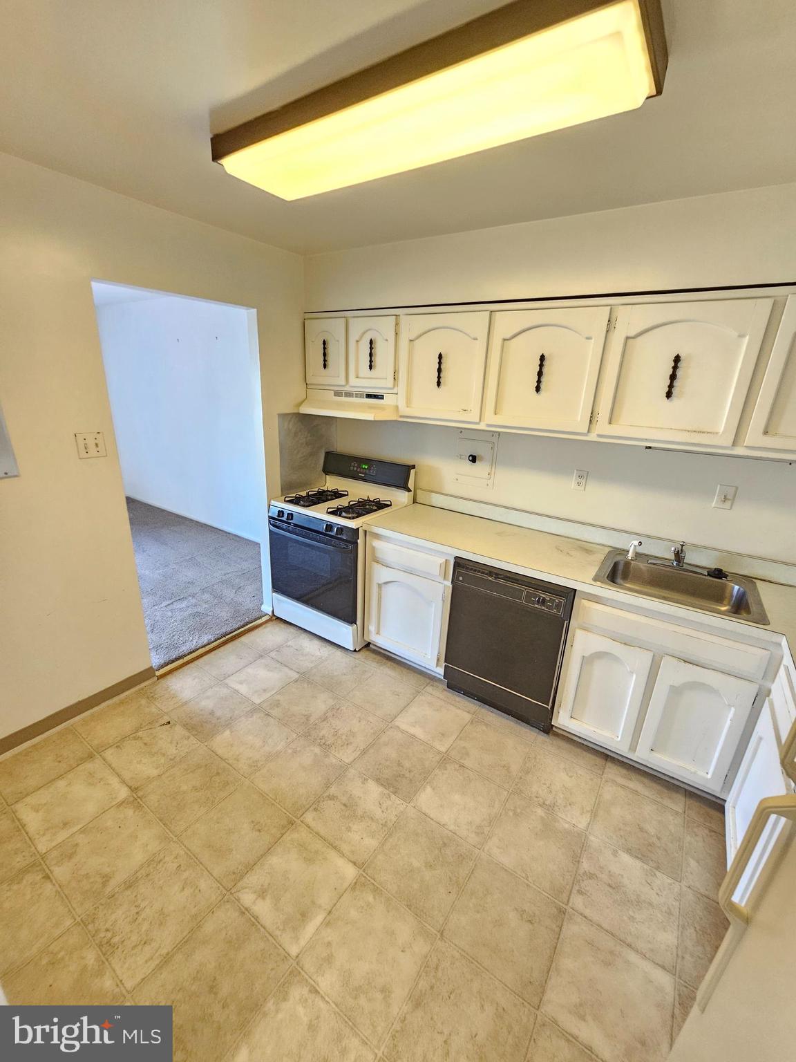 9900 Georgia Avenue, Unit 415 Silver Spring, MD 20902 - Photo 12 of 25 a kitchen with a stove top oven and cabinets