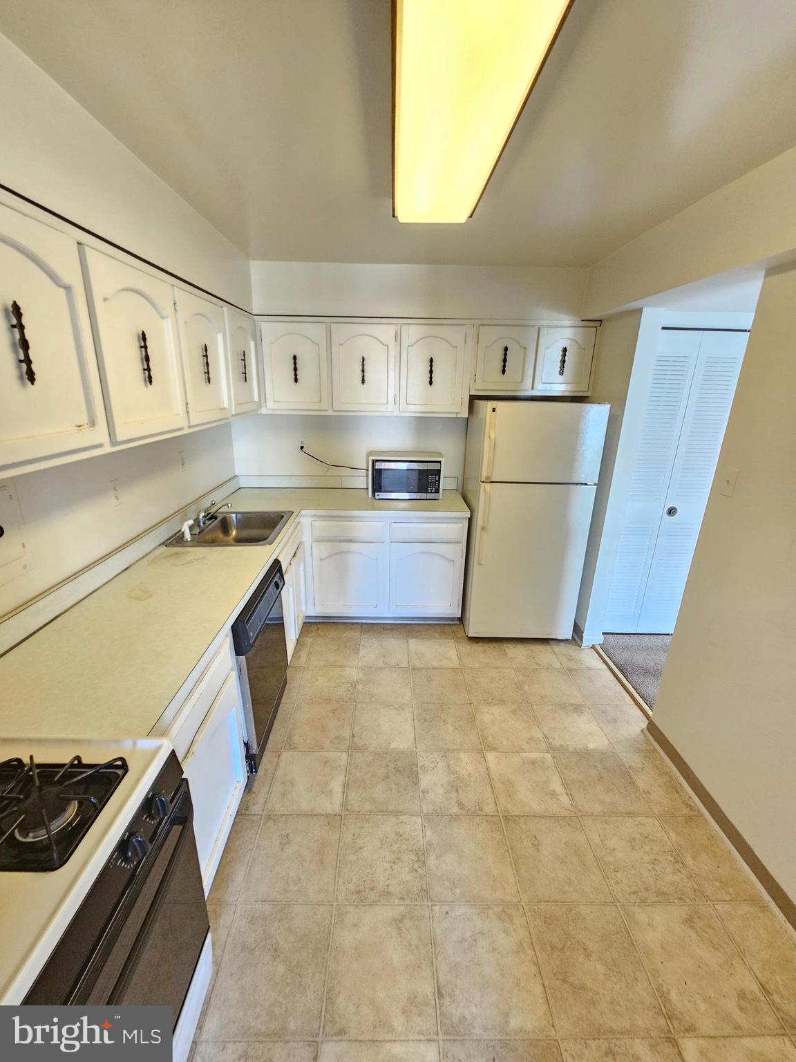 9900 Georgia Avenue, Unit 415 Silver Spring, MD 20902 - Photo 13 of 25 a kitchen with a stove a refrigerator and a sink