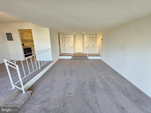 an empty room with a fireplace and windows