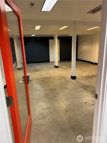 an empty room with kitchen and view of bathroom