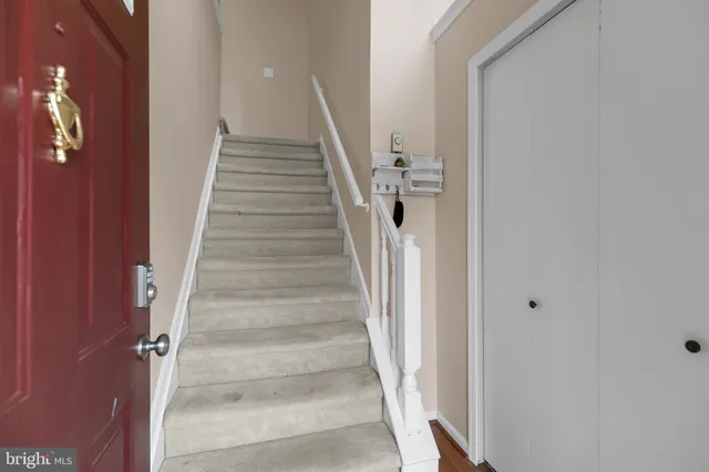 a view of staircase with white walls and white door