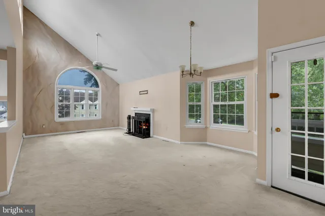 a view of an empty room with a window and fireplace