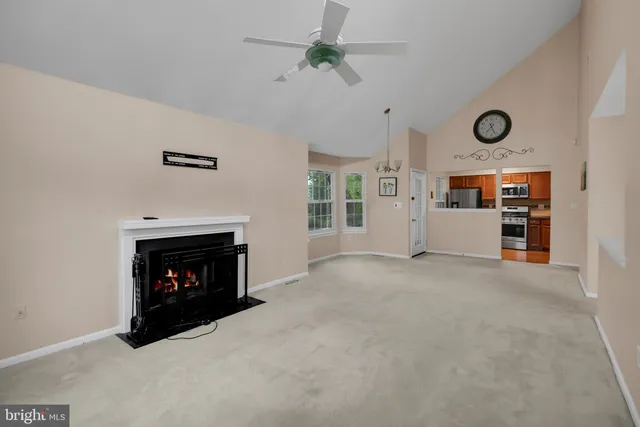 a view of an empty room with fireplace and fan