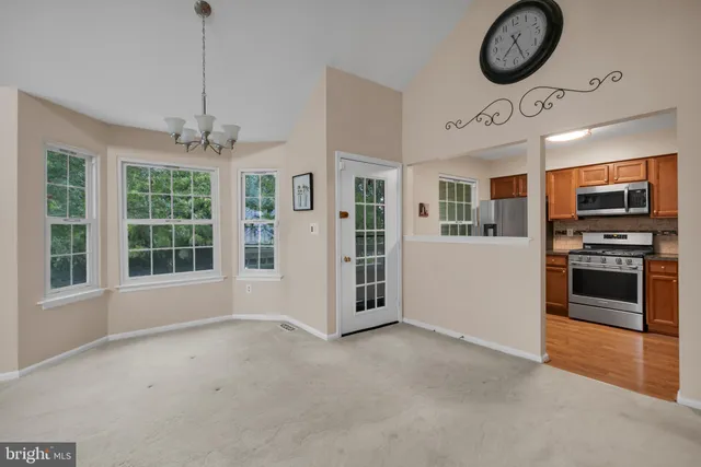 a view of a kitchen with stainless steel appliances granite countertop a stove and a refrigerator