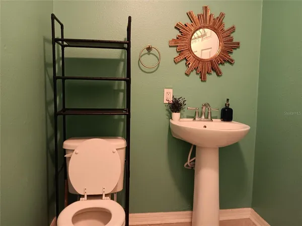 a bathroom with a sink mirror and toilet