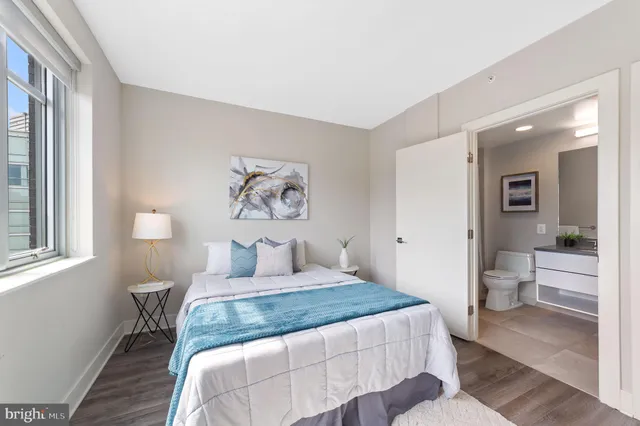 a bedroom with a large bed and a potted plant